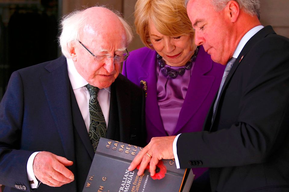 Irish President Michael Higgins, left, and his wife Sabina are presented with a book from Director of the Australian War Memorial Brendan Nelson during an official visit to the Australian War Memorial in Canberra, Monday, Oct. 16, 2017. (David Gray/Pool Photo via AP)