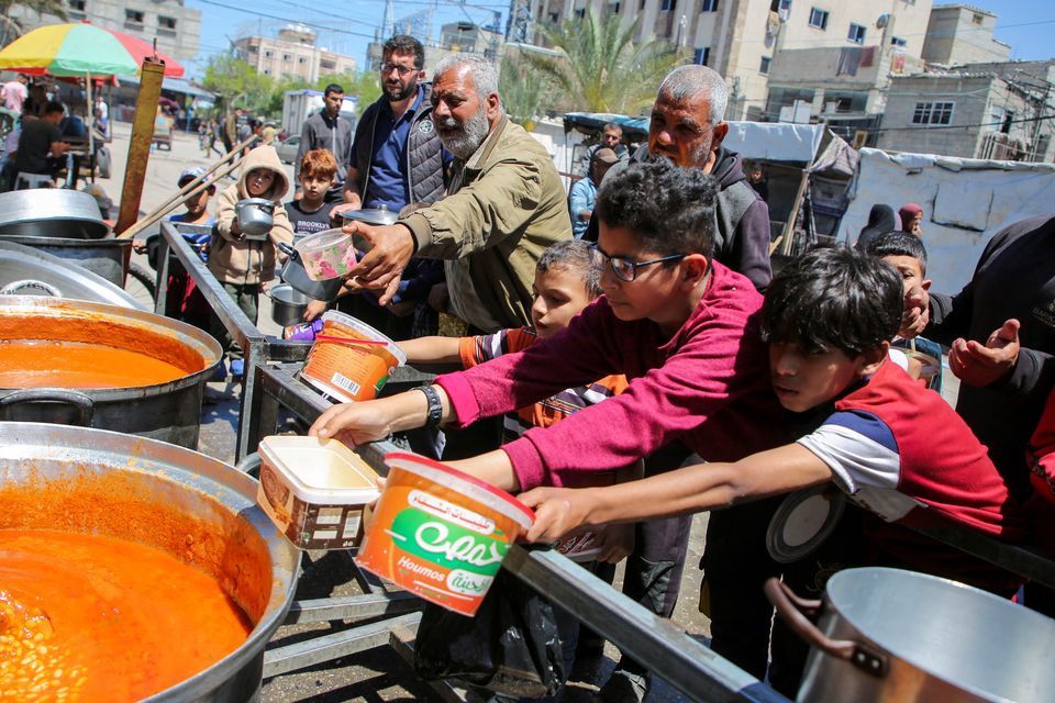 Palestinians gather to receive food cooked by a charity kitchen in Rafah, in the southern Gaza Strip, May 8, 2024. Photo: REUTERS/Hatem Khaled