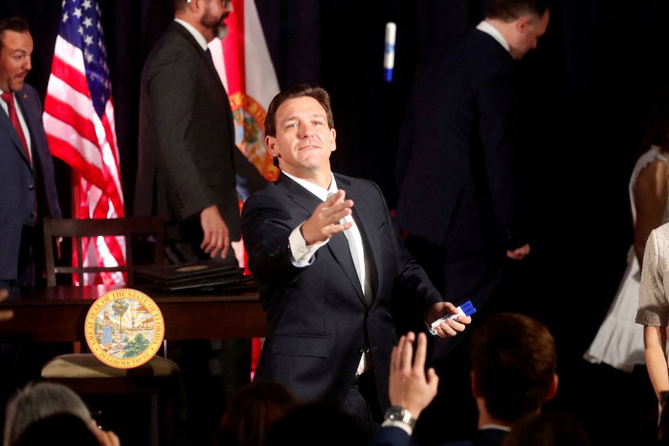 Florida Governor Ron DeSantis tosses pens to students while signing five state house bills into law after giving a press conference at Cambridge Christian School in Tampa.  Photo: Octavio Jones/Reuters