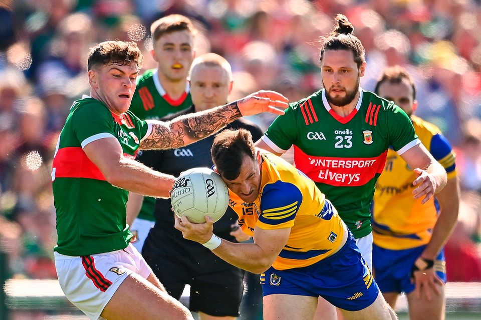 Diarmuid Murtagh of Roscommon is tackled by Jordan Flynn, left, and Pádraig O'Hora of Mayo during the All-Ireland SFC round two match at Dr Hyde Park in Roscommon. Photo: Ben McShane/Sportsfile