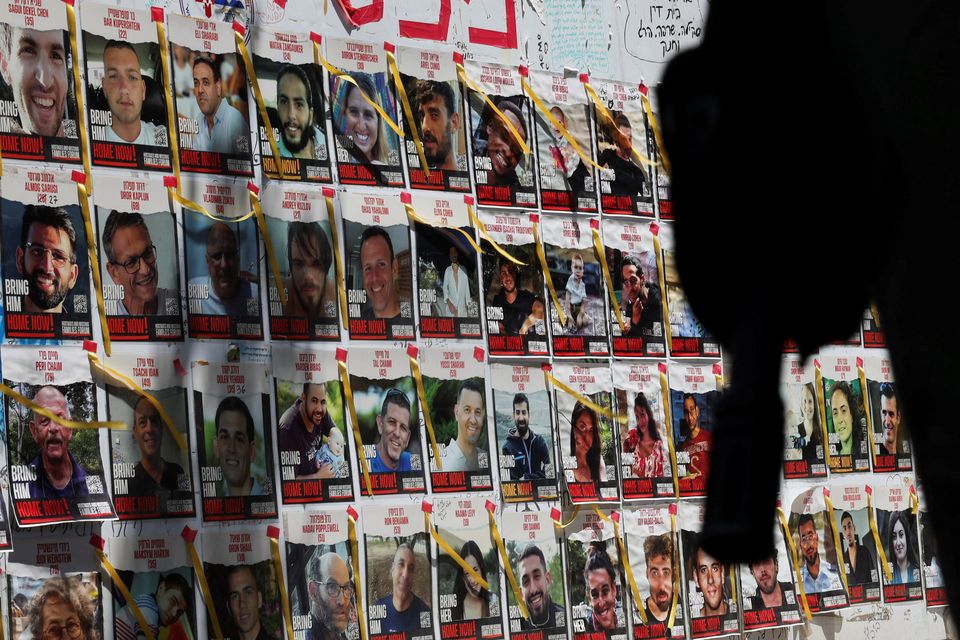 An Israeli soldier's rifle is silhouetted next to posters of hostages kidnapped during the deadly October 7 attack by Palestinian Islamist group Hamas from Gaza, at Dizengoff Square, in Tel Aviv, Israel. Photo: Reuters