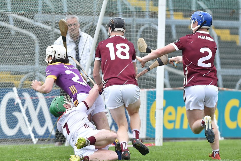 Rhys Wickham is taken down by Seán Kelly for Wexford's late penalty. Photo: Jim Campbell