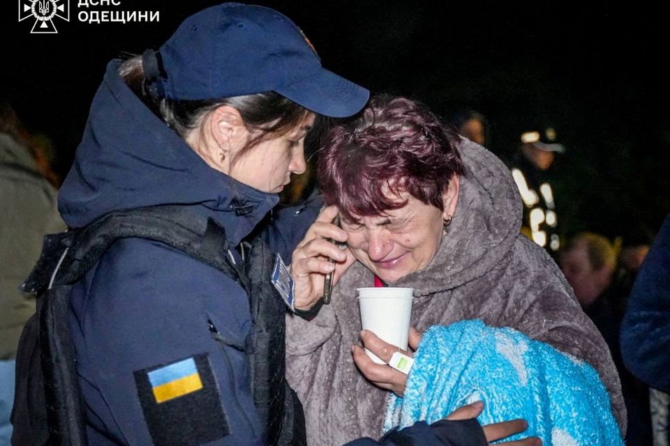 A psychologist from the Ukrainian emergency services comforts a local resident at the scene of a Russian drone strike in Odesa, Ukraine.  Photo: Reuters