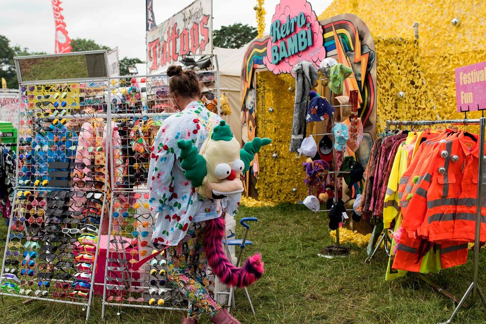 A reveller looks at merchandise displayed for sale at the Glastonbury Festival of Music and Performing Arts on Worthy Farm near the village of Pilton in Somerset, South West England, on June 26, 2019. (Photo by Oli SCARFF / AFP)OLI SCARFF/AFP/Getty Images