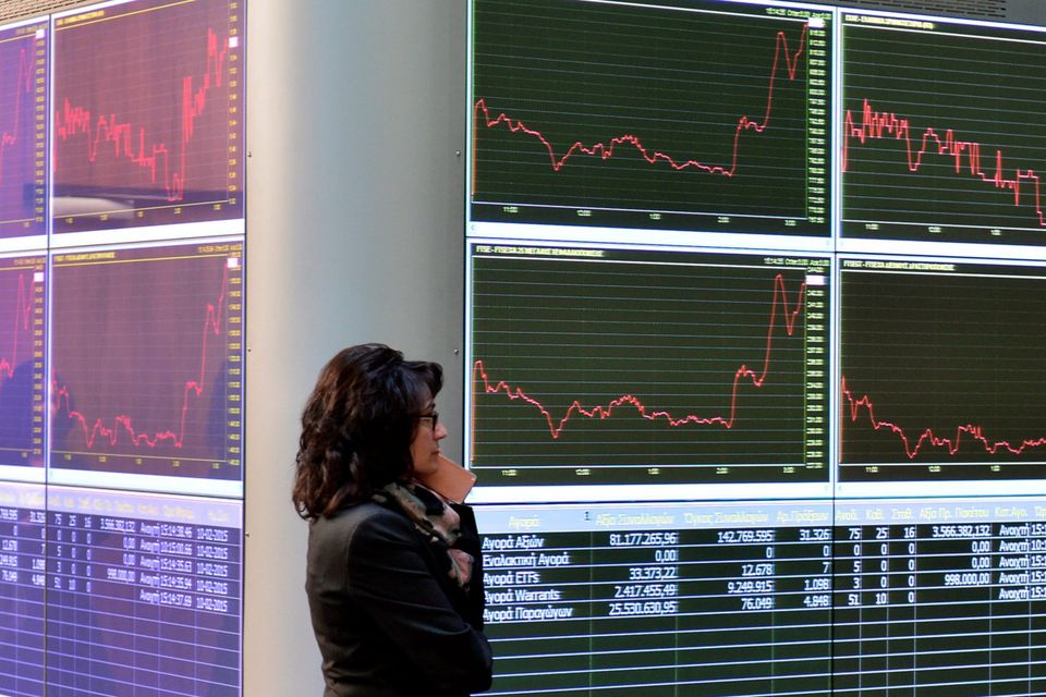 A worker at the Athens Stock Exchange stands in the reception hall as an electronic board displays stock prices. Getty Images