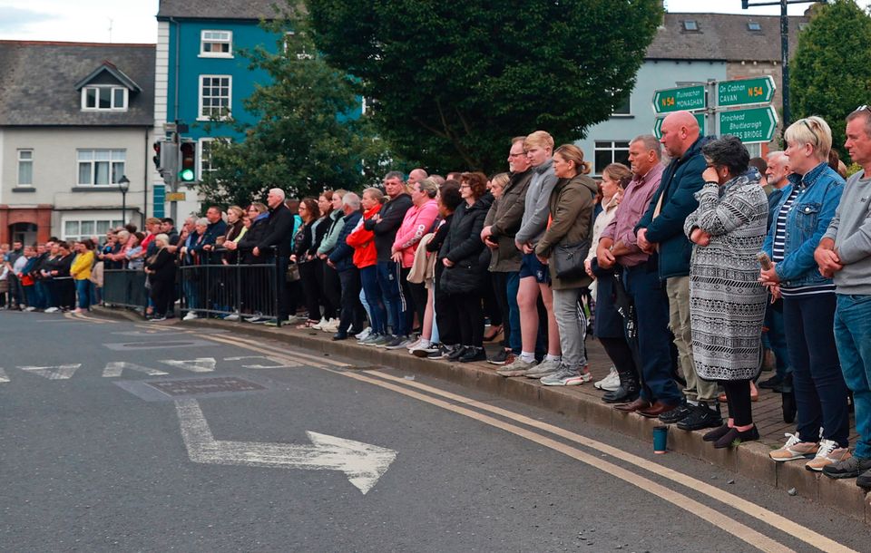 People await the hearse carrying the remains of Dlava Mohamed as they are brought to the family home in Clones, Co. Monaghan, on Wednesday evening. PA