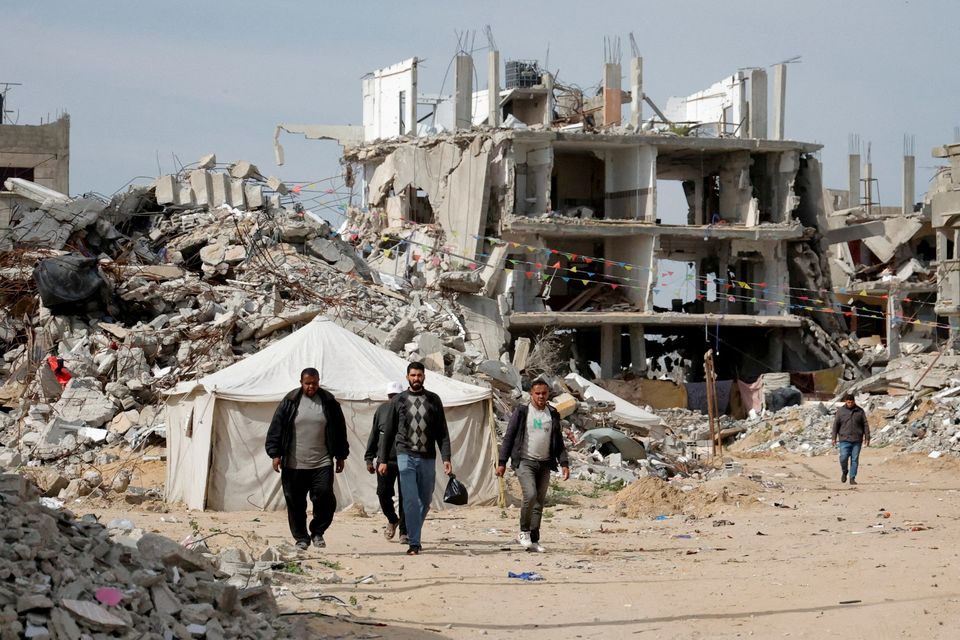 Palestinian men walk near the rubble of houses destroyed during the Israeli offensive, in Rafah, in the southern Gaza Strip. Photo: Reuters