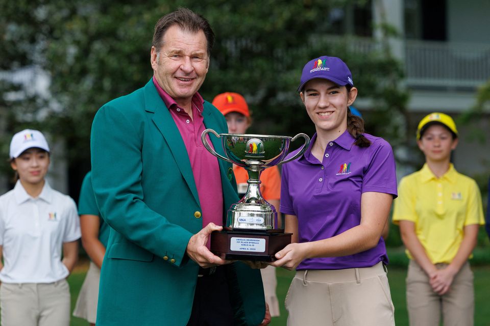 Masters champion Nick Faldo presents the 1st place over-all trophy to Abigail Henriksen of Deforest, Wisconsin in the Girls 14-15 year-old category at the Drive, Chip and Putt National Finals at the Augusta National Golf Club in Augusta, Georgia