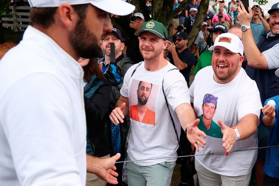 Scottie Scheffler is greeted by supporters after completing his second round at the USPGA