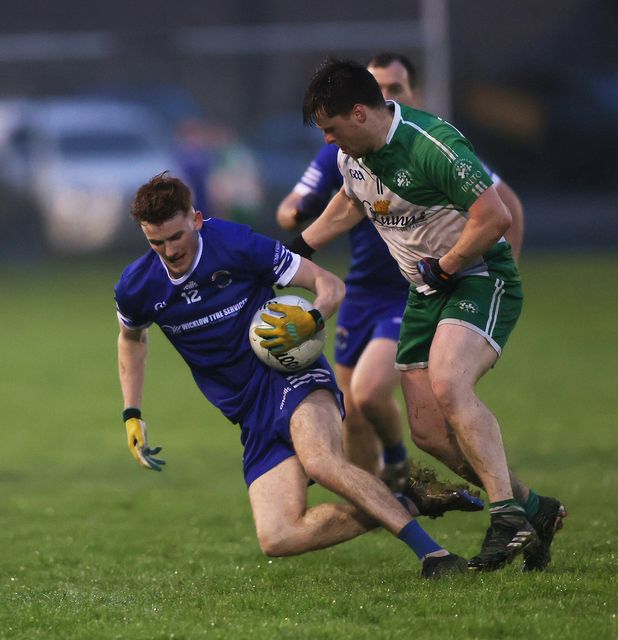 Ryan McConnell of St. Pat's goes to ground under pressure from Johnny Keogh of Baltinglass.  