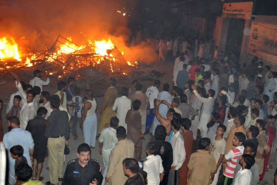 Police arrive after the houses of religious minority group Ahmadiyyas, were torched by a mob following accusations of blasphemy, in Gujranwala, Pakistan, 28 July 2014