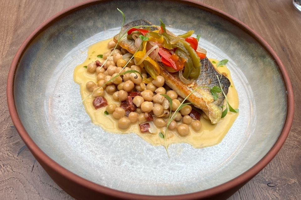 "I chose a fillet of pan-fried sea bass, which arrived perfectly seared, resting on a bed of chickpea emulsion with fine chorizo dice, and topped with a blaze of red and green piperade." Photo: Lucinda O'Sullivan