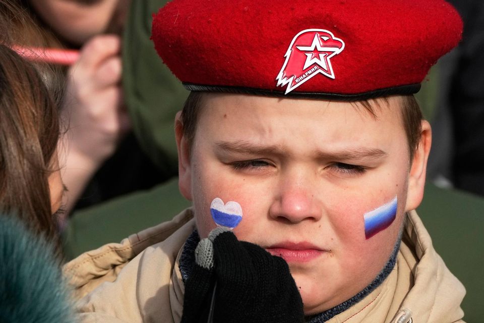 A woman paints Russian flags on the face of a member of Yunarmia (Young Army), an organisation sponsored by the Russian military that aims to encourage patriotism among the Russian youth. Photo: Dmitri Lovetsky/AP