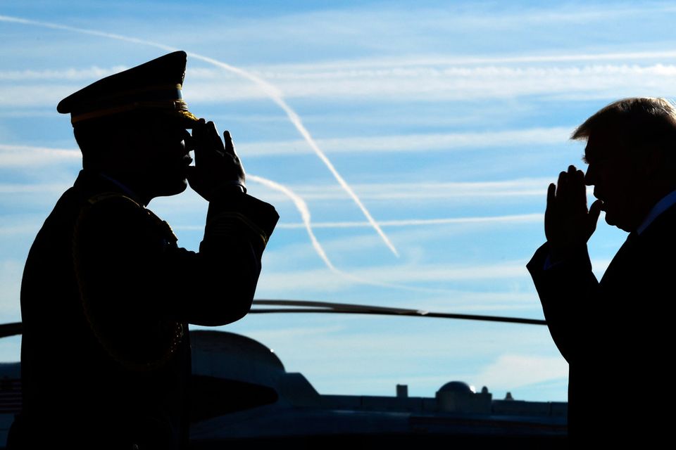 Hail to the chief: President Donald Trump is greeted with a salute as he walks down the steps of Air Force One at John F. Kennedy International Airport in New York on his return to his home city yesterday to attend a series of fundraisers Photo: AP Photo/Susan Walsh