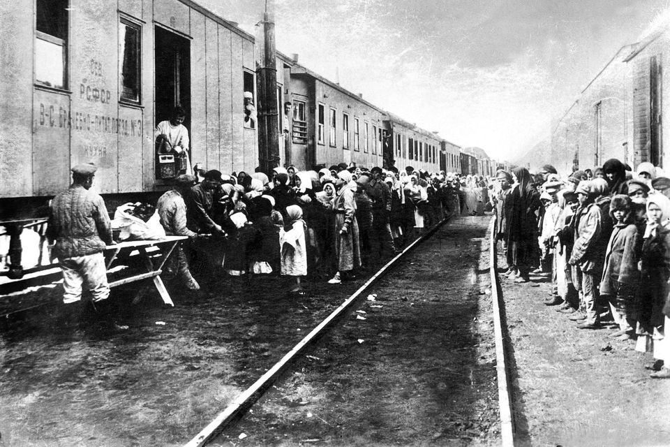 Life under the Gulag: Crowds gather beside a supplies train for starving Russians who had been deported to Siberia. Photo APIC/Getty Images
