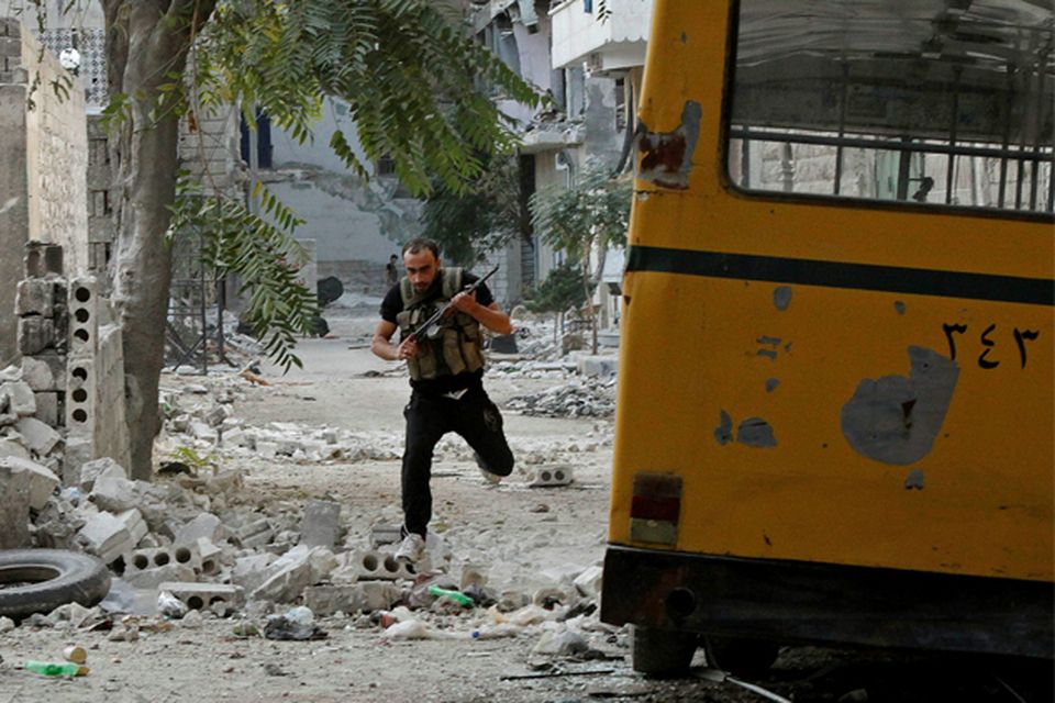A Free Syrian Army fighter runs to take cover from a sniper in Aleppo's Bustan al-Basha district. Photo: Reuters