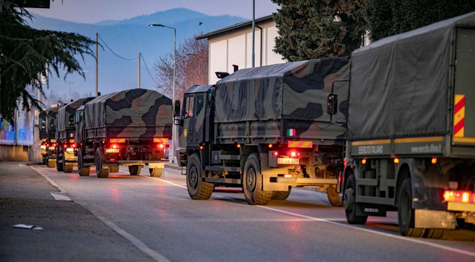 Italian military trucks drive through streets of Bergamo after the army were deployed to move coffins from the town.