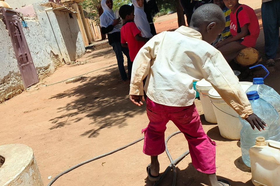 A child looks for water during clashes in Khartoum. Photo: Reuters/Mohamed Nureldin Abdallah