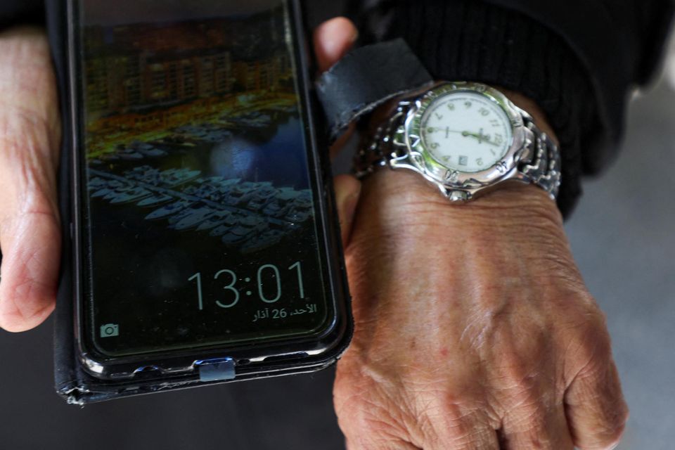 A man shows the differing times on his watch and phone in Beirut. Photo: Mohamed Azakir/Reuters