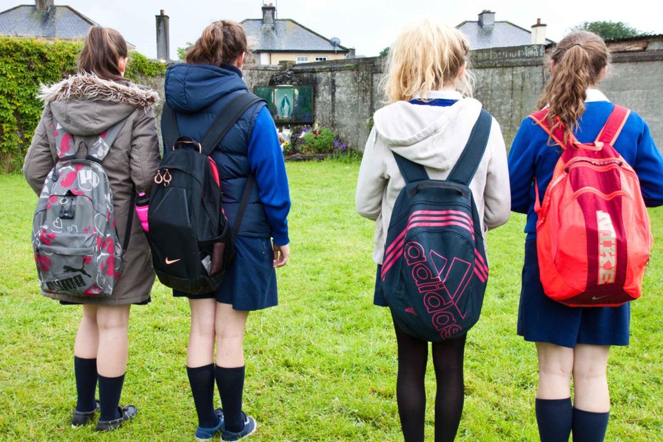 Schoolgirls pay their respects at the site of the unmarked grave at the mother and babies home in Tuam, Co Galway. Photo: Andy Newman