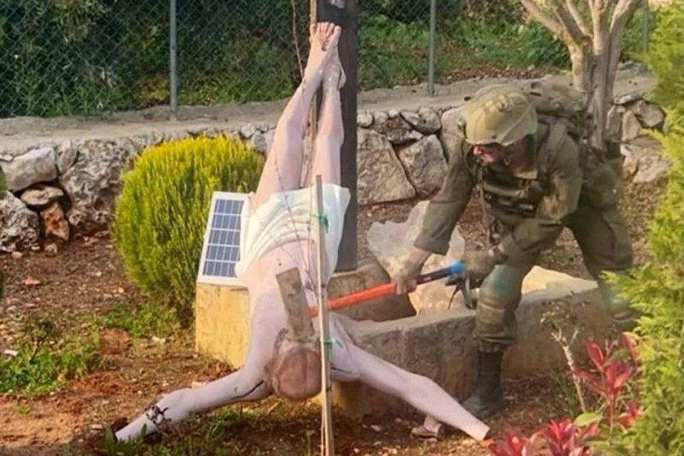 An Israeli Defence Forces soldier damages the face of a statue of Jesus at a shrine outside the village of Debel, southern Lebanon. Photo: Reuters