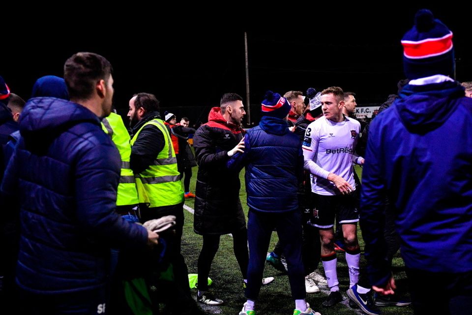 Members of both teams and backroom staff tussle at the final whistle