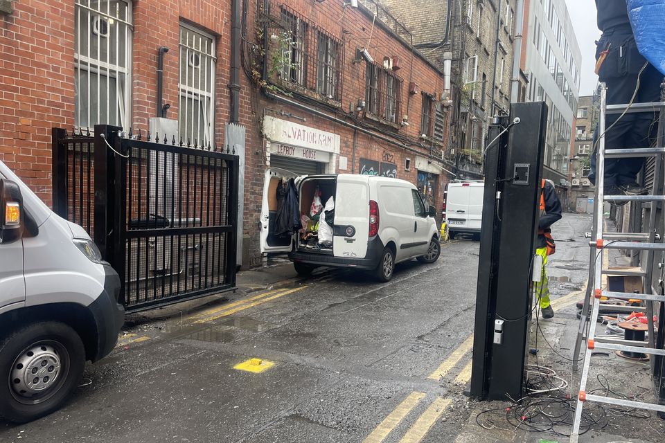 Workers erect double gates at the wider Marlborough Street entrance to Harbour Court