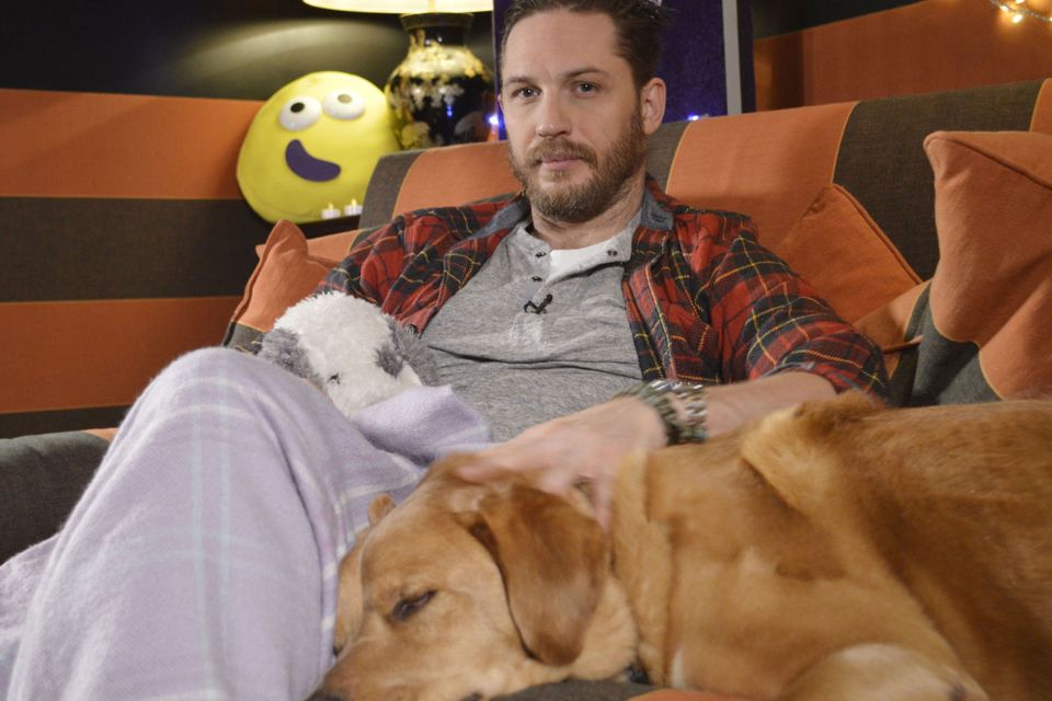 Tom Hardy as he cuddles up to his dog for his new role - as a bedtime storyteller on CBeebies (BBC/PA)