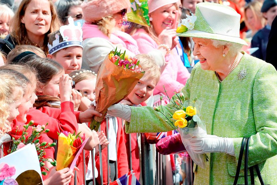 Britain’s Queen Elizabeth II greets well-wishers on her 90th birthday in Windsor, England; inset left: a royal fan waits in the crowd. Photo: AFP/Getty Images