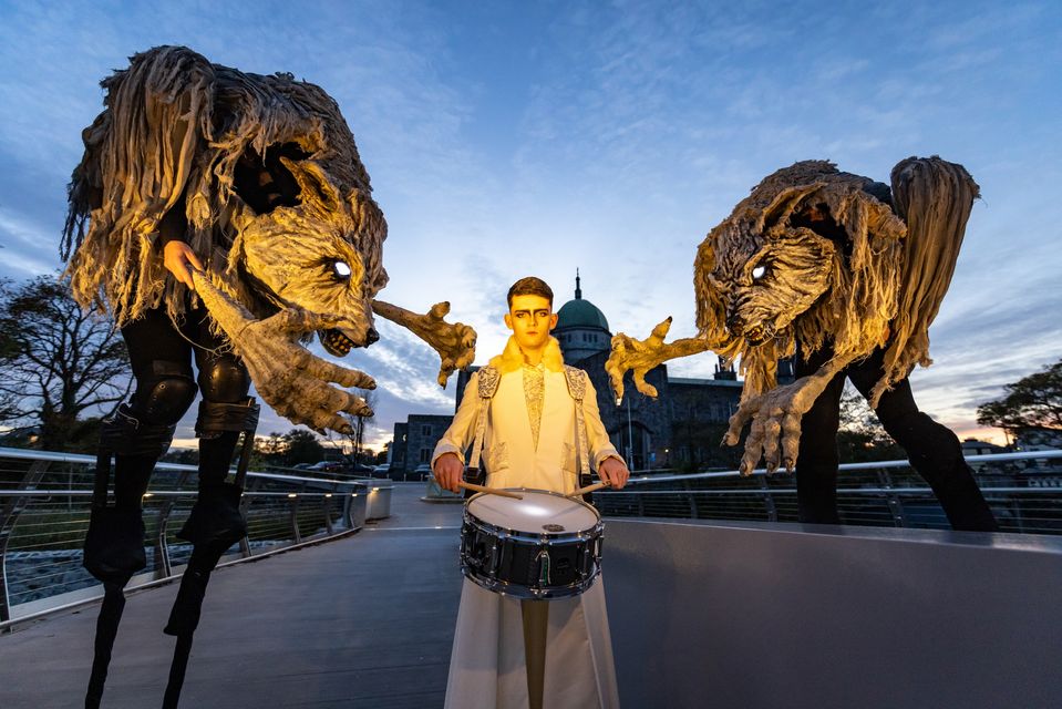 Drummer Liam McMahon marches with two of La Loba’s wolves ahead of the Macnas parade in Galway city on Sunday, Photo: Emilija Jefremova