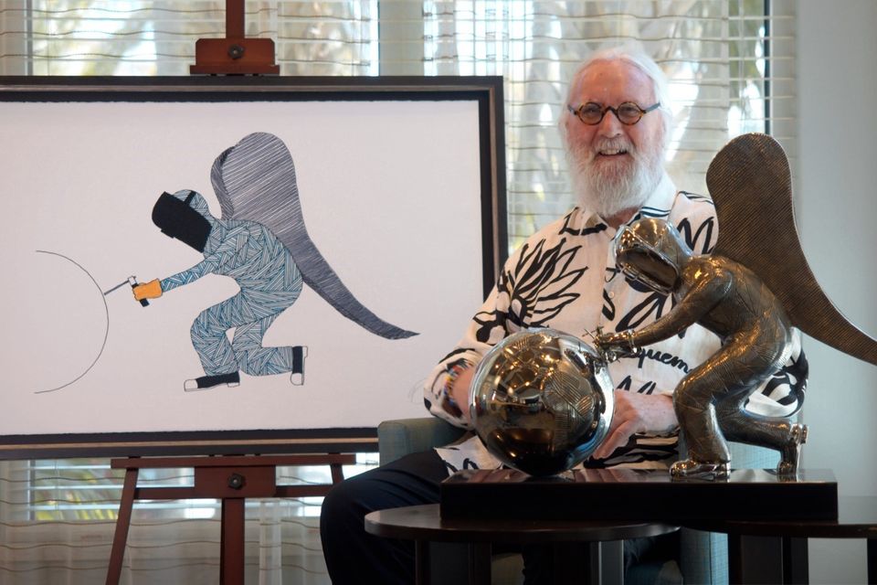 Billy Connolly sits next to his newest painting and sculpture, And On Monday, God Made the World (Castle Fine Art/PA)