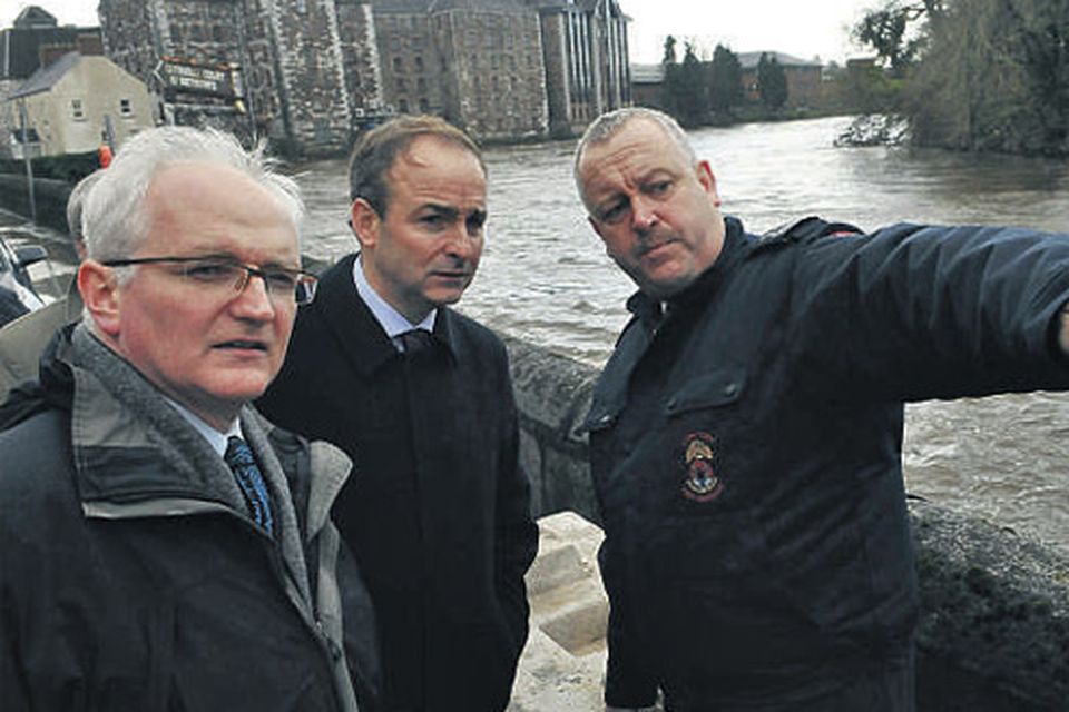 Environment Minister John Gormley (left) Foreign Affairs Minister Micheal Martin and Chief Fire Officer John Reyn (right) assess flood
damage at the Mercy University Hospital, Cork, where the River Lee burst its banks and collapsed a wall