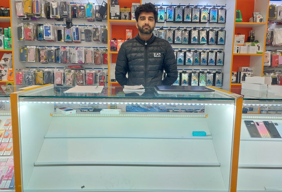 Waqas Khan se encuentra detrás de un mostrador vacío después de que una banda enmascarada se incautara de 60.000 euros en existencias de la tienda de teléfonos móviles iFix en Dundalk.
