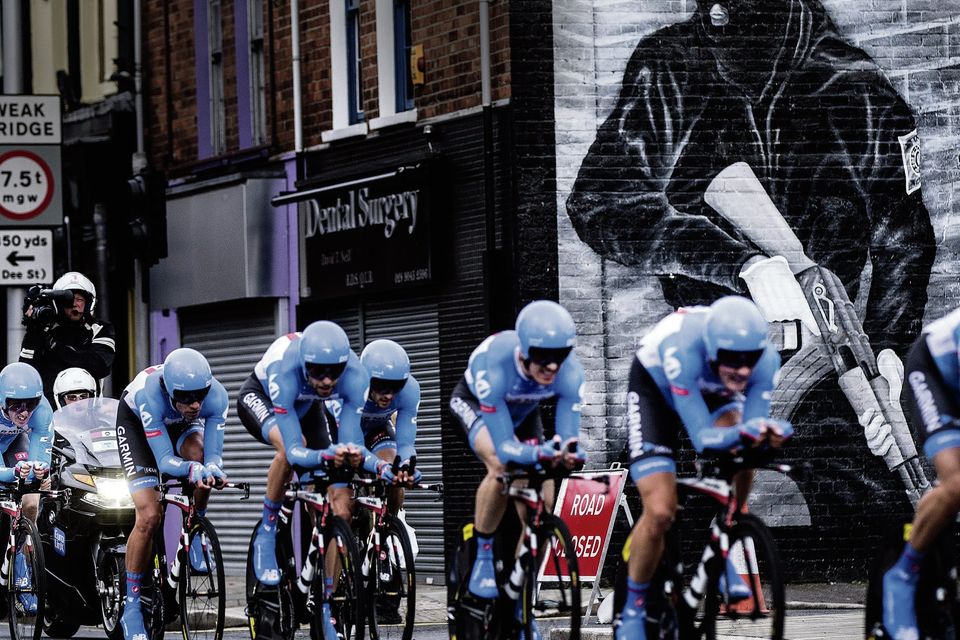 PAST, PRESENT AND FUTURE: Cyclists in the Giro d’Italia go past a mural on the Newtownards Road in Belfast yesterday, a reminder of the past Lord Bew remembers too well: “I was motivated by a sense that the Troubles were over and should never be allowed to happen again.” Photo: David Conachy