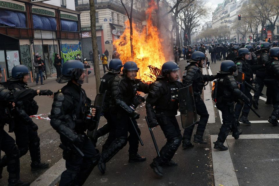 French riot police walk near a fire during clashes with protesters at a demonstration against the government's pension reform, in Paris, France, March 23, 2023. REUTERS/Nacho Doce