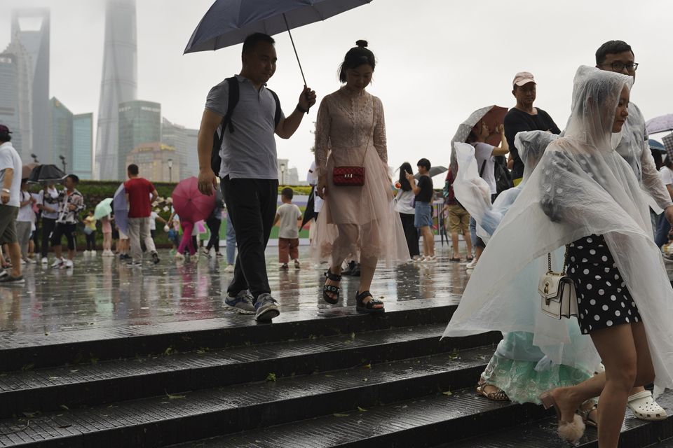 Visitors leave from the bund as Typhoon Lekima approaches in Shanghai (Erika Kinetz/AP)