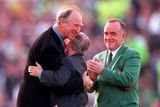 thumbnail: 30 May 2000; Republic of Ireland equipment officer Charlie O'Leary, centre, is embraced by former Republic of Ireland manager Jack Charlton, left, after he was presented with a momento for his services to Irish soccer, as Pat Quigley, President of the Football Association of Ireland, watches on during the International Friendly match between Republic of Ireland and Scotland at Lansdowne Road in Dublin. Photo by David Maher/Sportsfile