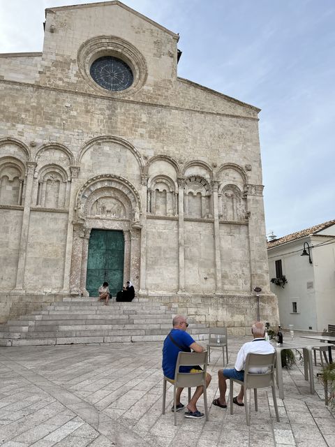 Two men sit with drinks in front of the Cathedral of Saint Mary of the Purification in Termoli. Photo: Chico Harlan/The Washington Post
