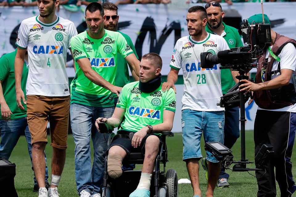 Chapecoense players Neto, left, goalkeeper Follmann, on the wheelchair, and Alan Ruschel, right, the three players that survived the air crash, arrive for an Sudamericana trophy award ceremony prior to a friendly match against Palmeiras, in Chapeco, Brazil
