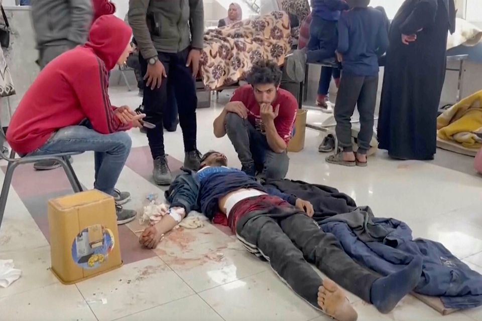 An injured man is tended to on floor of Al-Shifa Hospital on Thursday after Israeli troops fired on a crowd of Palestinians waiting for aid in Gaza City. Photo: AP Photo