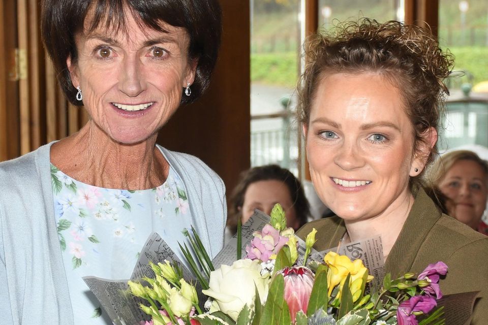 Garda Catherine O'Rourke presents Patricia McCarthy with a bouquet of flowers.