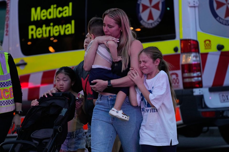 People are led out from the Westfield Shopping Centre where multiple people were stabbed in Sydney, Saturday, April 13, 2024. T(AP Photo/Rick Rycroft)