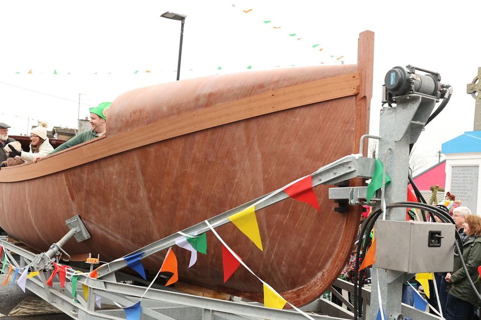 The replica Helen Blake lifeboat passes the monument in Fethard village during the 2023 St Patrick's Parade. Photos: Liam Ryan