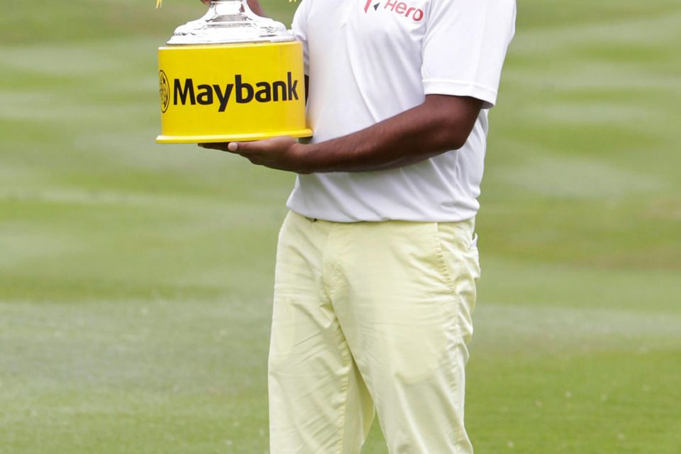 Anirban Lahiri of India poses with his trophy for photographers after winning the Malaysian Open golf tournament at Kuala Lumpur Golf