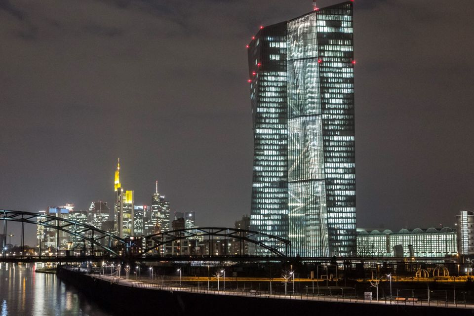 The European Central Bank (ECB) headquarters, right, are illuminated by light as the building stands on the skyline by the River Main in Frankfurt, Germany, on Friday, March 6, 2015. The final countdown is under way for the European Central Bank's program of government-bond purchases, which already fueled a debt-market rally that sent yields across the euro region to record lows. Photographer: Martin Leissl/Bloomberg