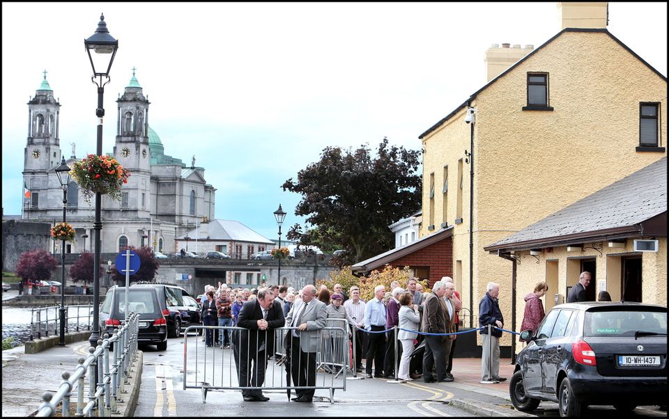 Crowds gather at Flynn's Funeral Home on The Strand along the banks of the Shannon for Larry and Martina Hayes tragically killed in Tunisia who were reposing there. In the backround is the Church of St Peter and Paul where the funeral mass will take place.
Pic Steve Humphreys
2nd July 2015.