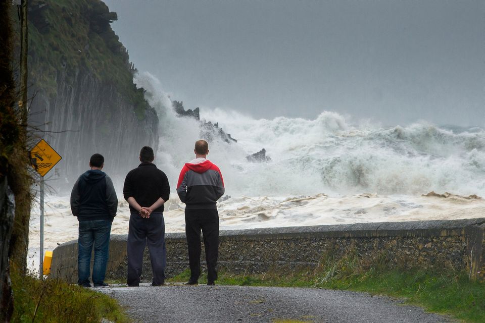 The O'Sullivan family look out from the Glen Pier as Ophelia strikes the Co Kerry. Photo: Stephen Kelleghan