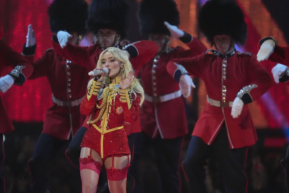 Sabrina Carpenter paid homage to British culture at the Brits, wearing a red military-style blazer dress on stage, with performers in military parade dress following her (Lucy North/PA)