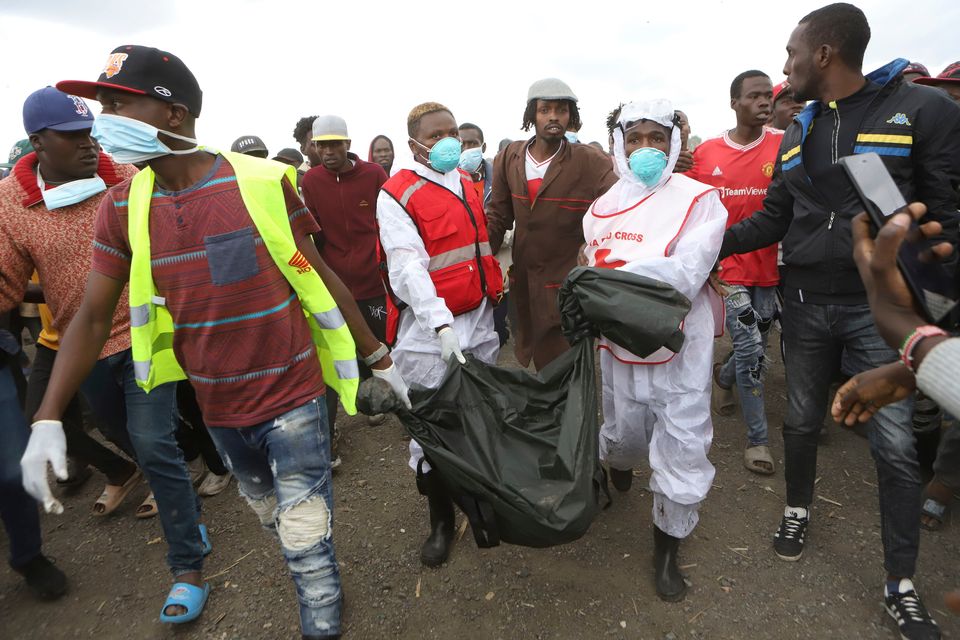 Workers remove bags containing human remains from a quarry in Kware, near Nairobi. Photo: AP