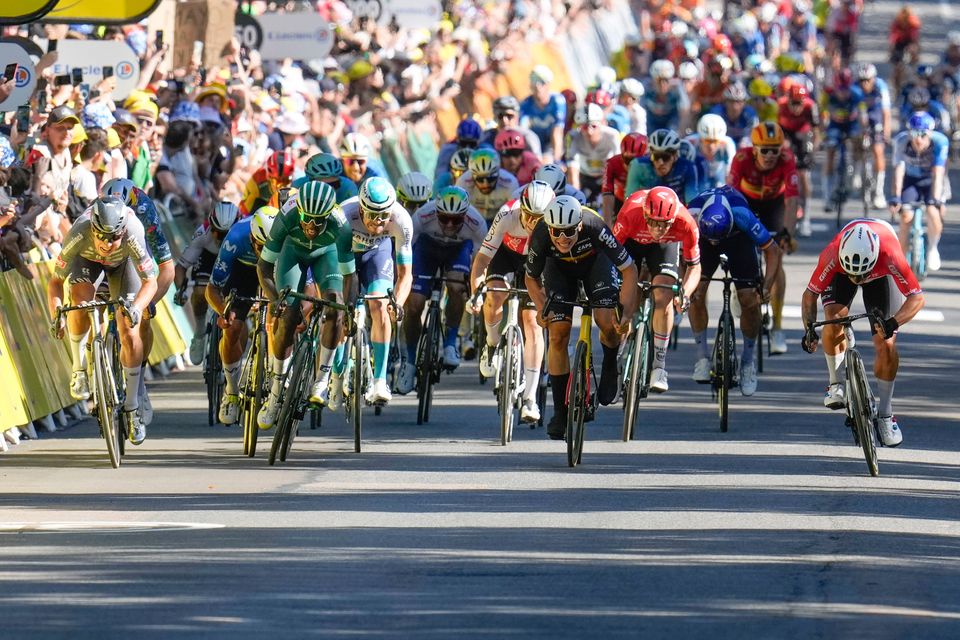 Dutchman Dylan Groenewegen, far right, sprints to the finish line to win ahead of Belgian Jasper Philipsen, far left, and second-placed Eritrean Biniam Girmay, who wears the green jersey for best sprinter during the sixth stage of the Tour de France from Macon to Dijon